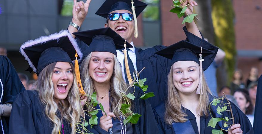 Happy and excited students in their caps and gowns after receiving their ivy at SPU